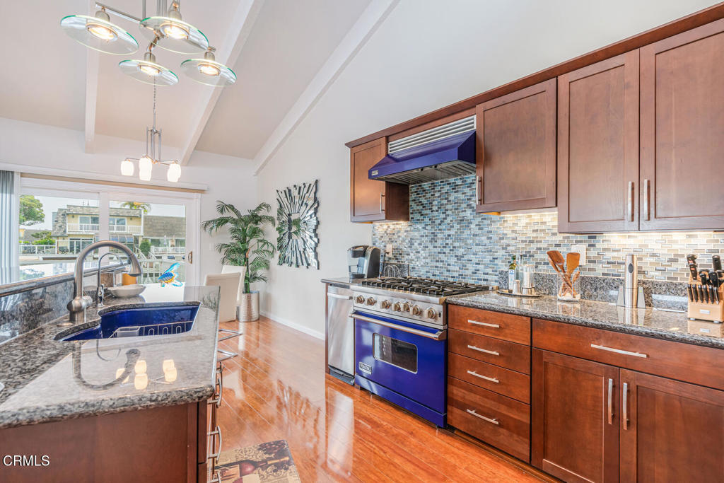 4604 Falkirk Bay Oxnard, CA 93035 - Photo 11 of 40 a kitchen with stainless steel appliances granite countertop a stove a sink dishwasher and cabinets with wooden floor