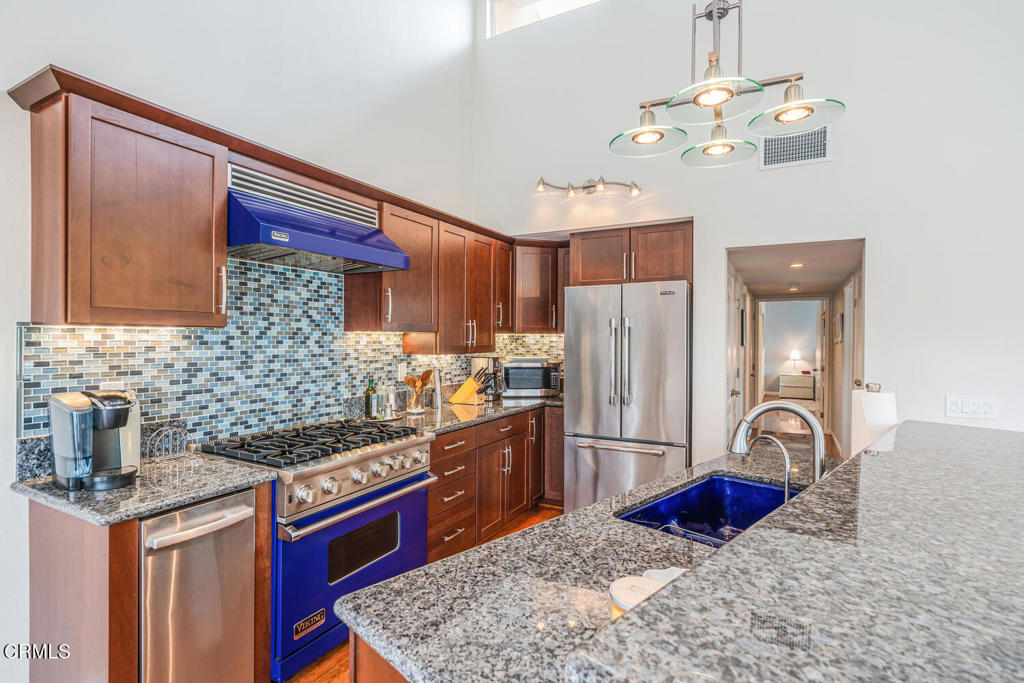 4604 Falkirk Bay Oxnard, CA 93035 - Photo 12 of 40 a kitchen with stainless steel appliances granite countertop a stove a refrigerator and a wooden cabinets