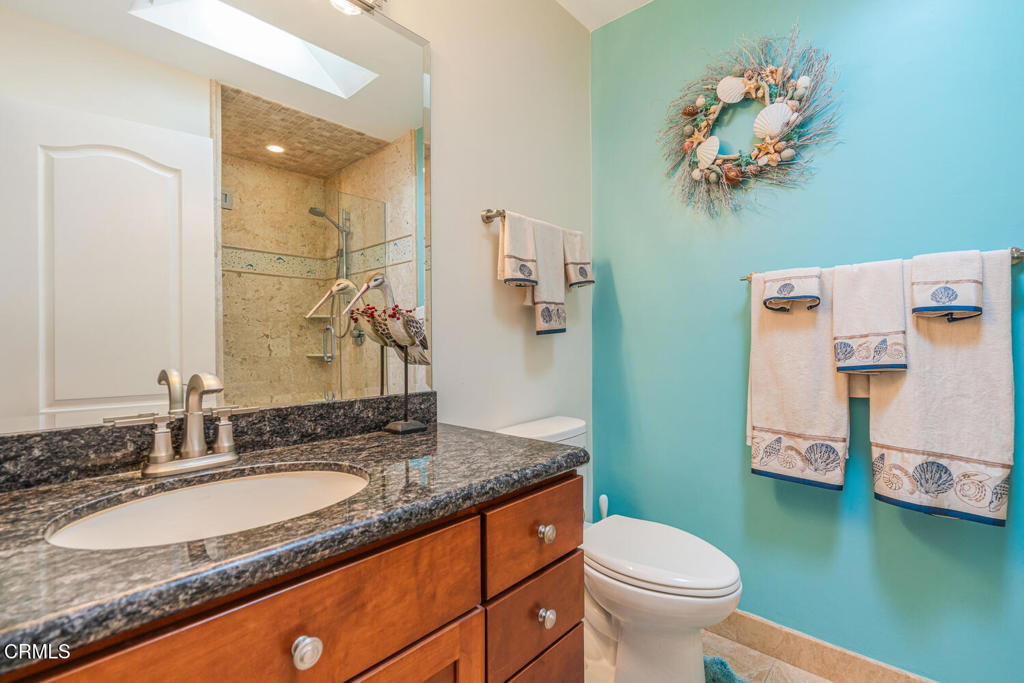 4604 Falkirk Bay Oxnard, CA 93035 - Photo 17 of 40 a bathroom with a granite countertop sink a toilet and a mirror