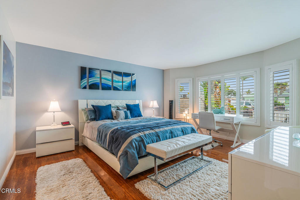 4604 Falkirk Bay Oxnard, CA 93035 - Photo 19 of 40 a bedroom with a large bed a couch and large window