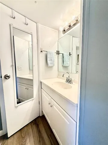 a bathroom with a granite countertop sink a mirror and shower