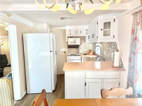 a kitchen with a sink refrigerator and cabinets
