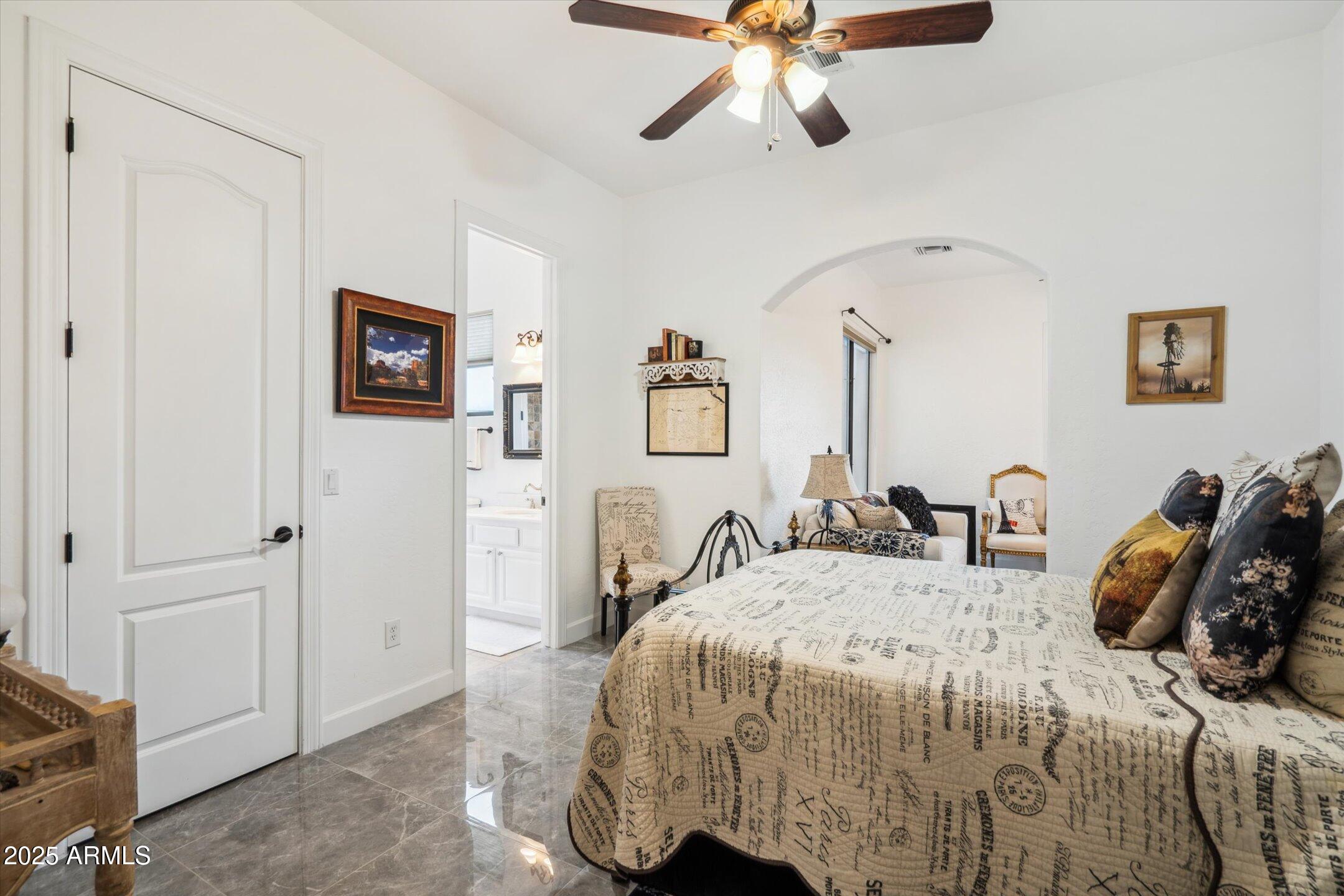 619 North Sun Road Apache Junction, AZ 85119 - Photo 30 of 72 a bedroom with a bed and a chandelier