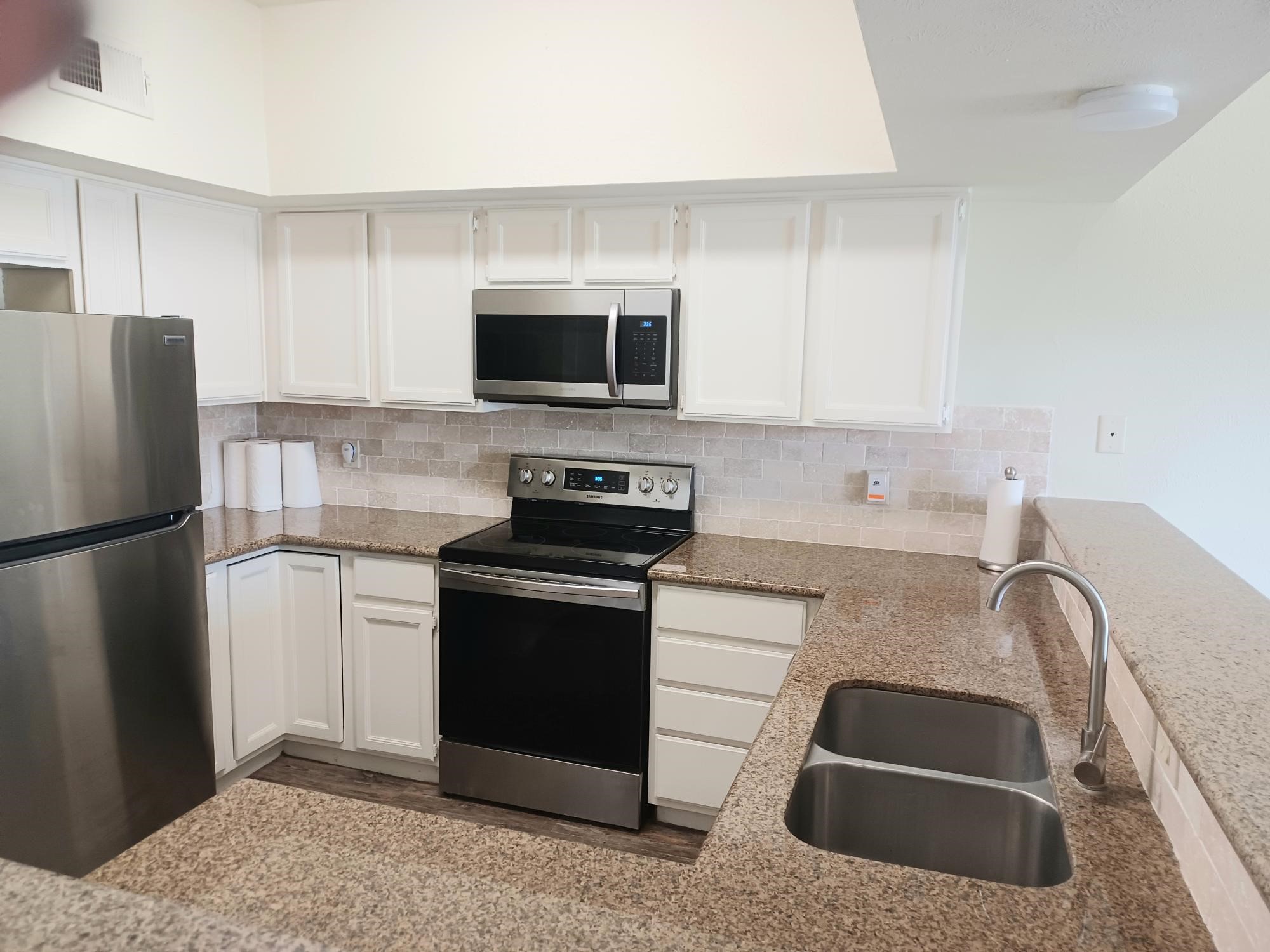 128 April Point Drive South Conroe, TX 77356 - Photo 10 of 26 a kitchen with stainless steel appliances granite countertop a refrigerator sink and stove
