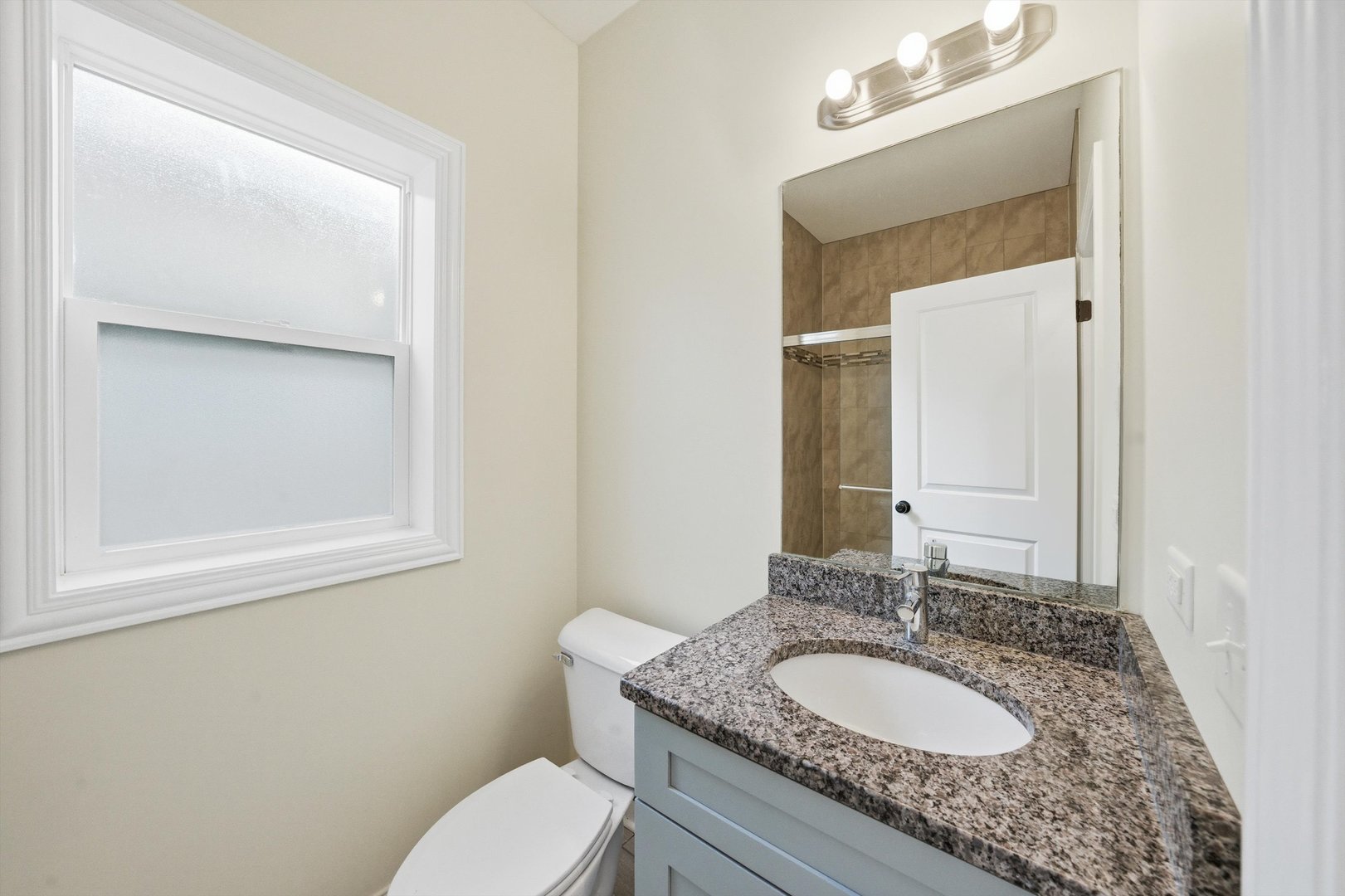 4063 South Rockwell Street Chicago, IL 60632 - Photo 11 of 24 a bathroom with a granite countertop toilet a sink and a mirror