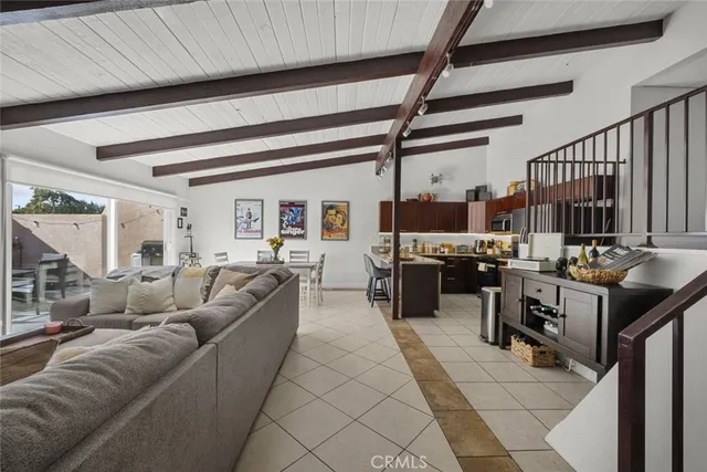 a living room with lots of furniture and kitchen view