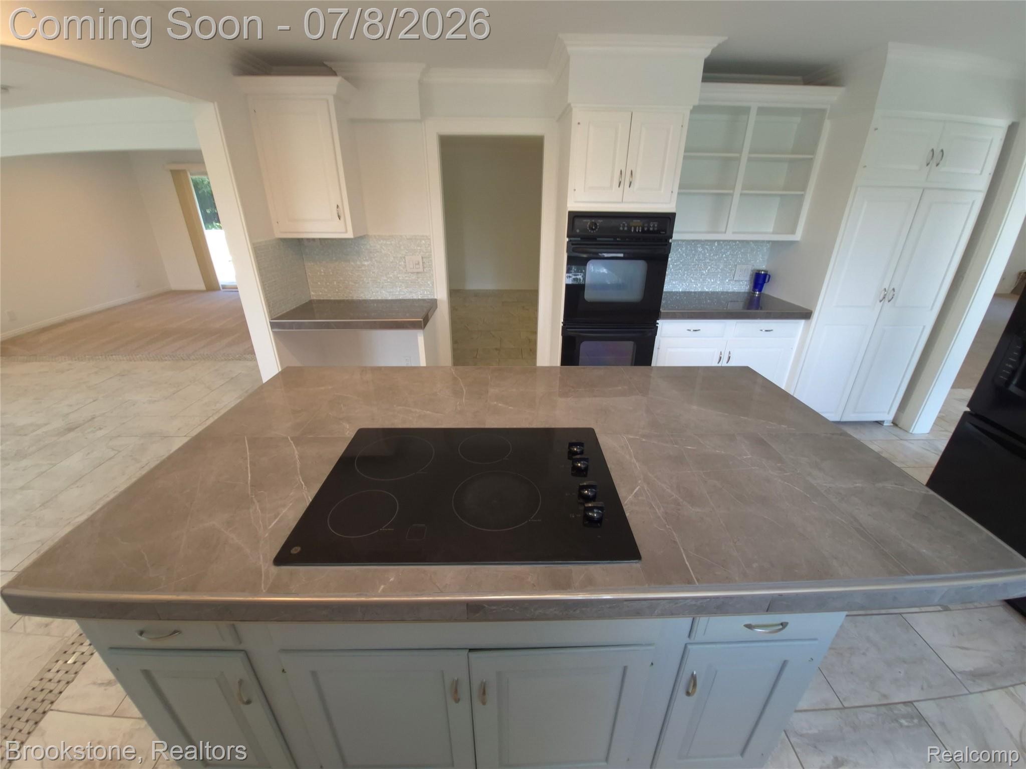 4140 South Henderson Road Davison, MI 48423 - Photo 22 of 98 Kitchen island with an integrated cooktop, grey stone-finish countertop, and light blue base cabinetry