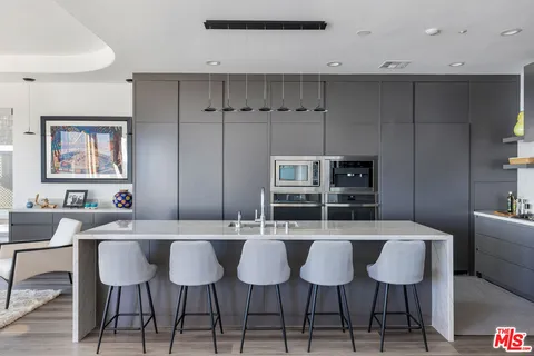 a kitchen with a dining table chairs and white cabinets