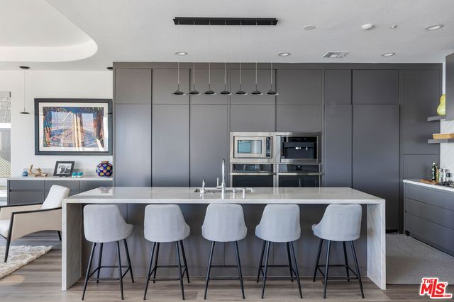 a kitchen with a dining table chairs and white cabinets
