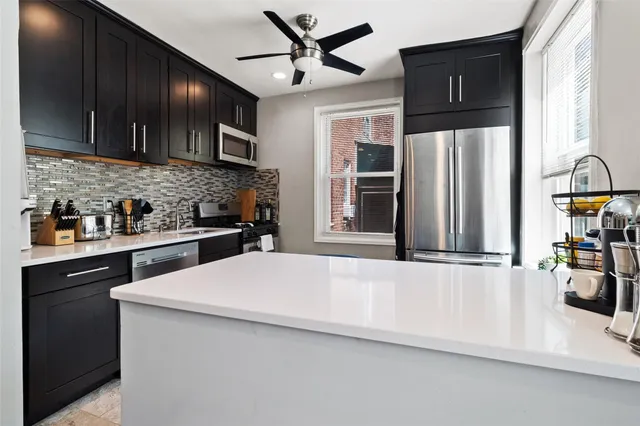 a kitchen with stainless steel appliances a refrigerator and a stove top oven