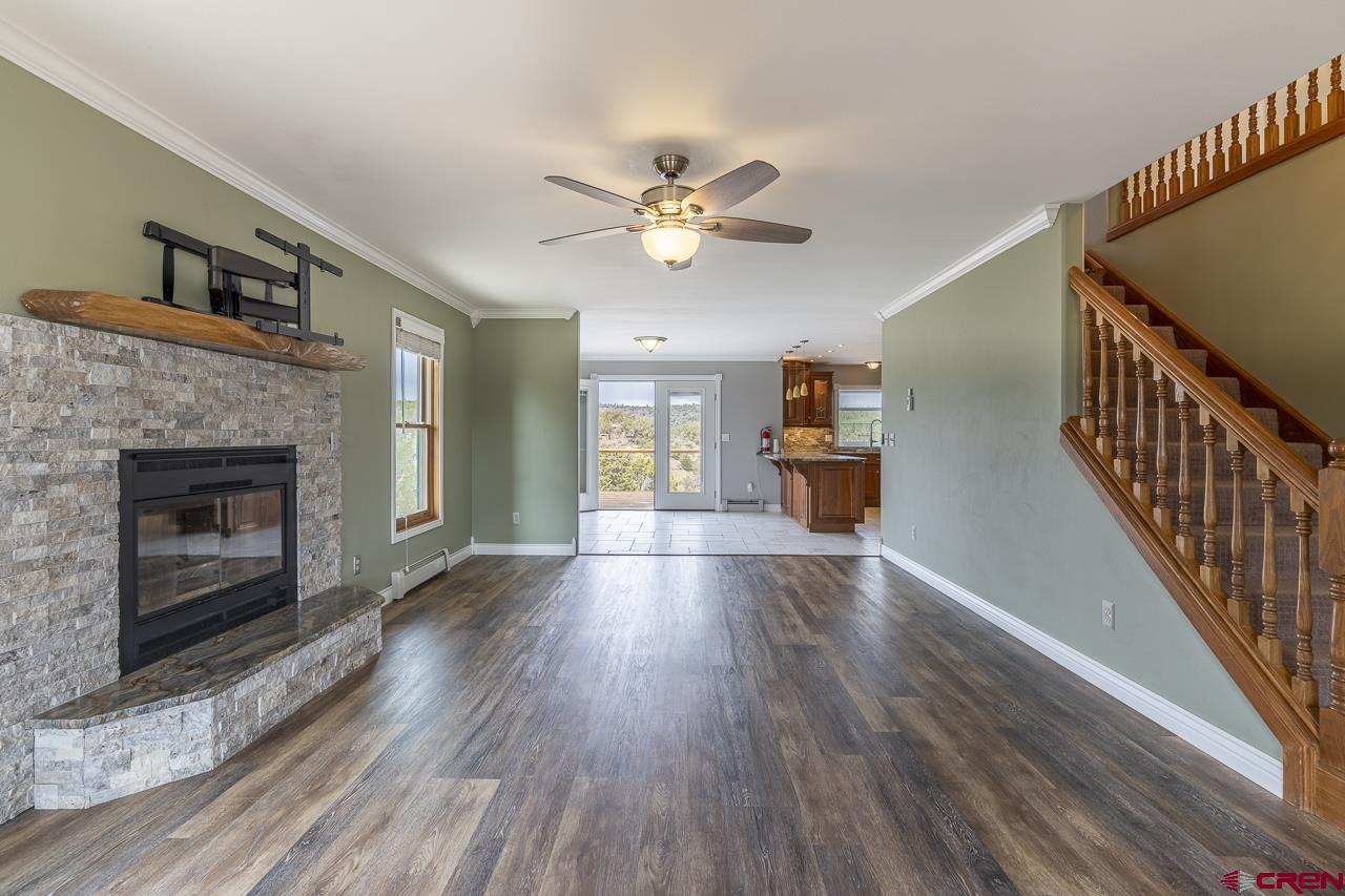 1403 Skyview Road Bayfield, CO 81122 - Photo 4 of 35 a view of an empty room with wooden floor fireplace and a window