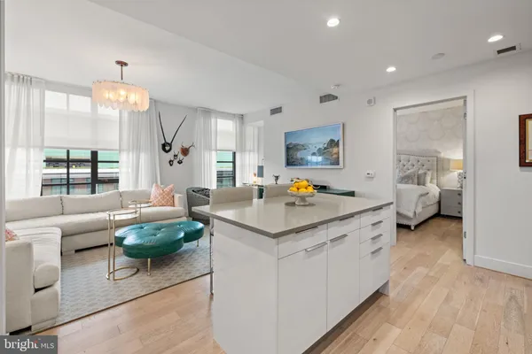 a living room with furniture and a dining table with wooden floor