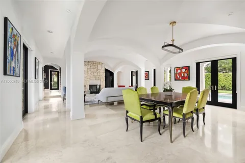 a view of a dining room and livingroom with furniture a rug a flat screen tv and a chandelier