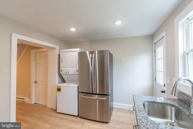 a kitchen with stainless steel appliances granite countertop a refrigerator a sink and a granite counter tops