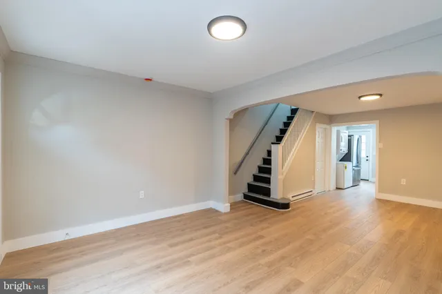 an empty room with wooden floor and stairs