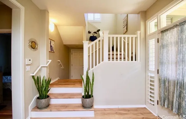 a view of a hallway with wooden floor and a potted plant