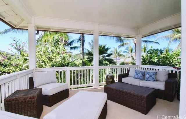 a balcony with furniture and a potted plant