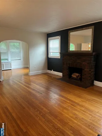 a view of an empty room with window and fireplace