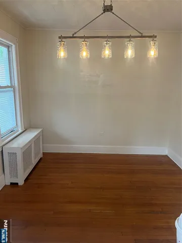 a view of a room with wooden floor and white walls