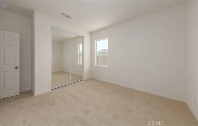 an empty room with windows and closet