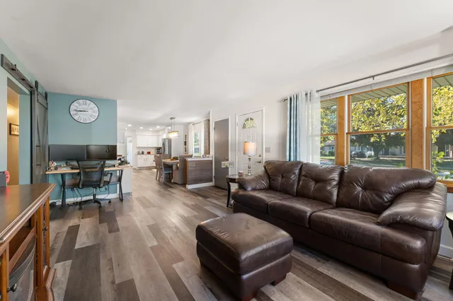 a living room with furniture wooden floor and a large window