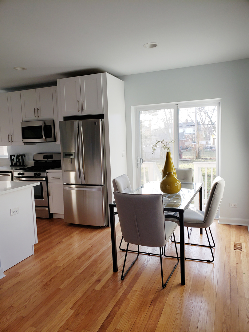 57 Northgate Road Riverside, IL 60546 - Photo 5 of 28 a kitchen with a table chairs refrigerator and cabinets