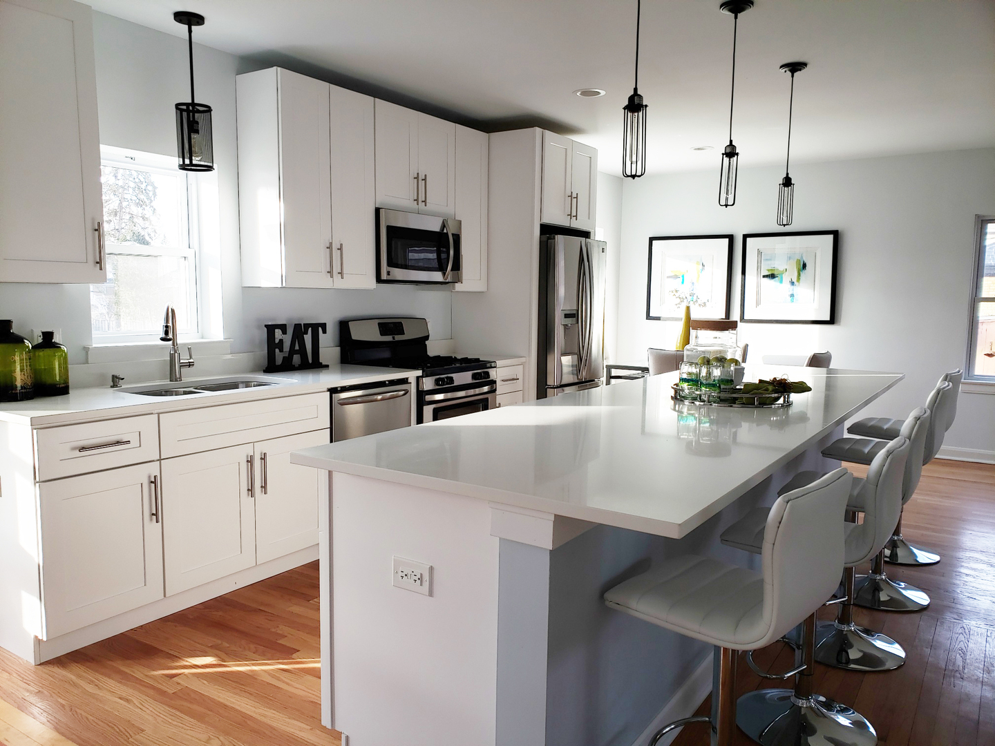 57 Northgate Road Riverside, IL 60546 - Photo 10 of 28 a kitchen with stainless steel appliances a sink a stove a refrigerator cabinets and a dining table with wooden floor