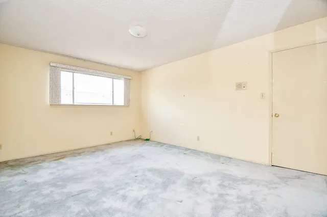 an empty room with closet and windows