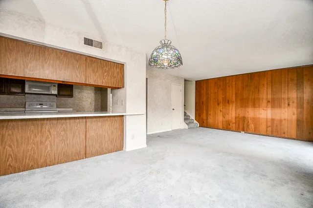 a view of an empty room with a kitchen