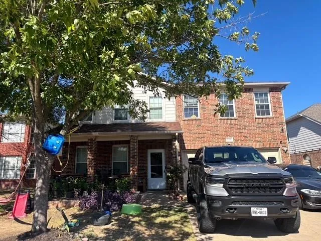 a view of a house with a tree in front of it