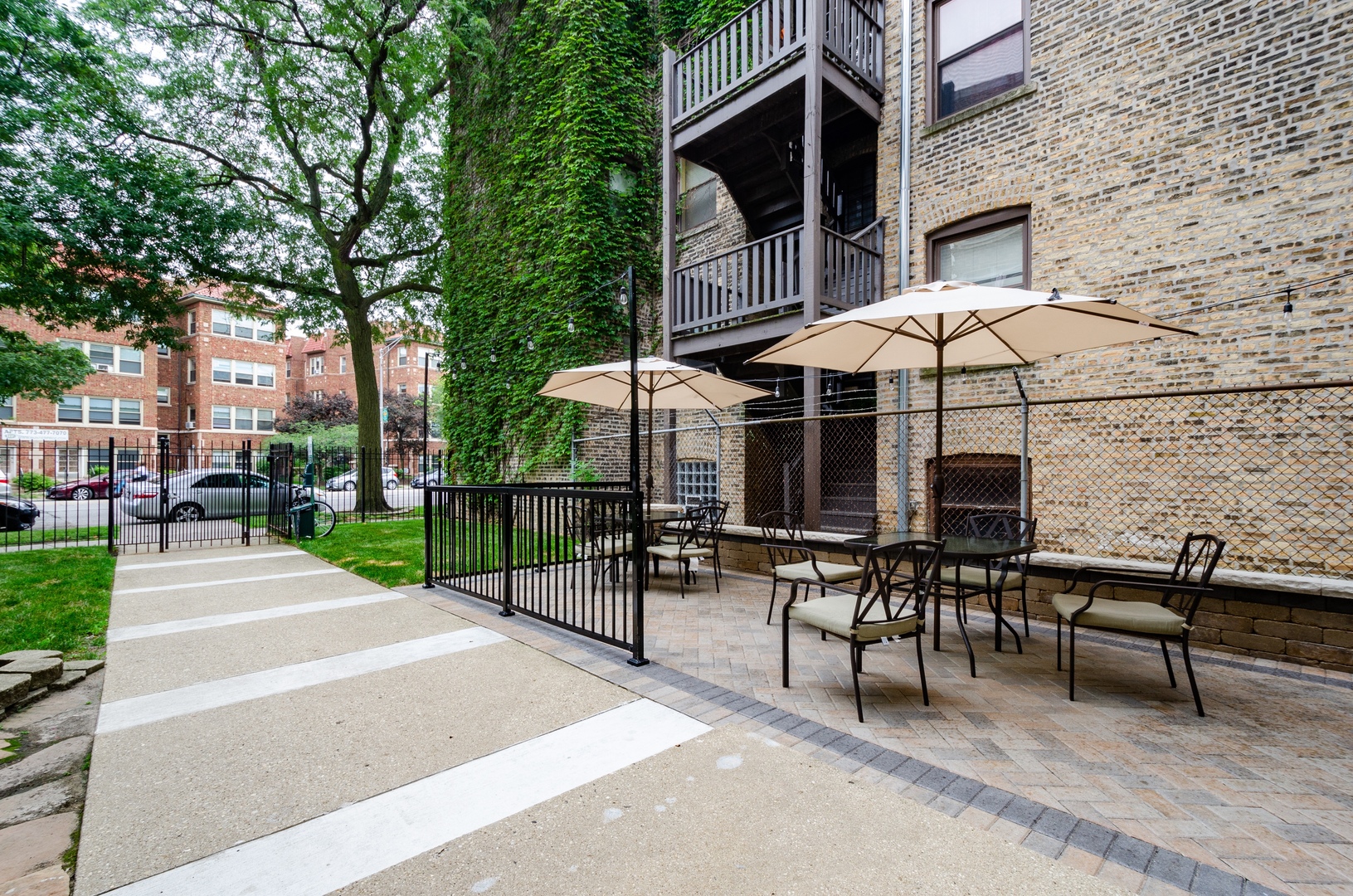 7710 North Sheridan Road, Unit 304 Chicago, IL 60626 - Photo 11 of 13 a patio with a table and chairs under an umbrella