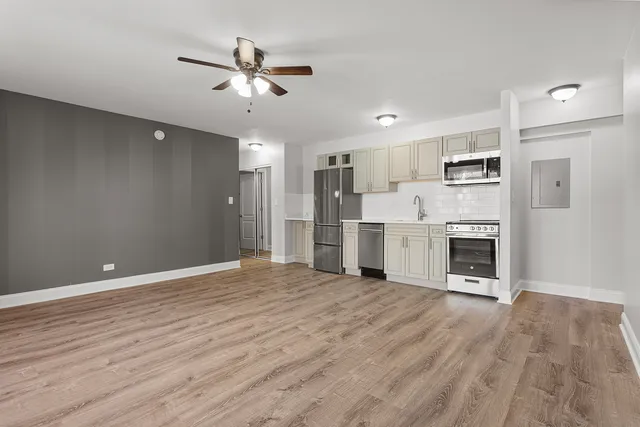 a view of a livingroom with a kitchen fireplace and wooden floor