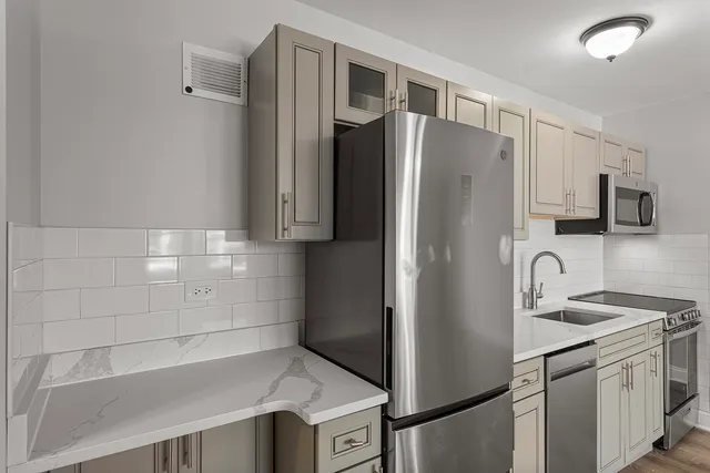 a kitchen with stainless steel appliances granite countertop a refrigerator and a sink