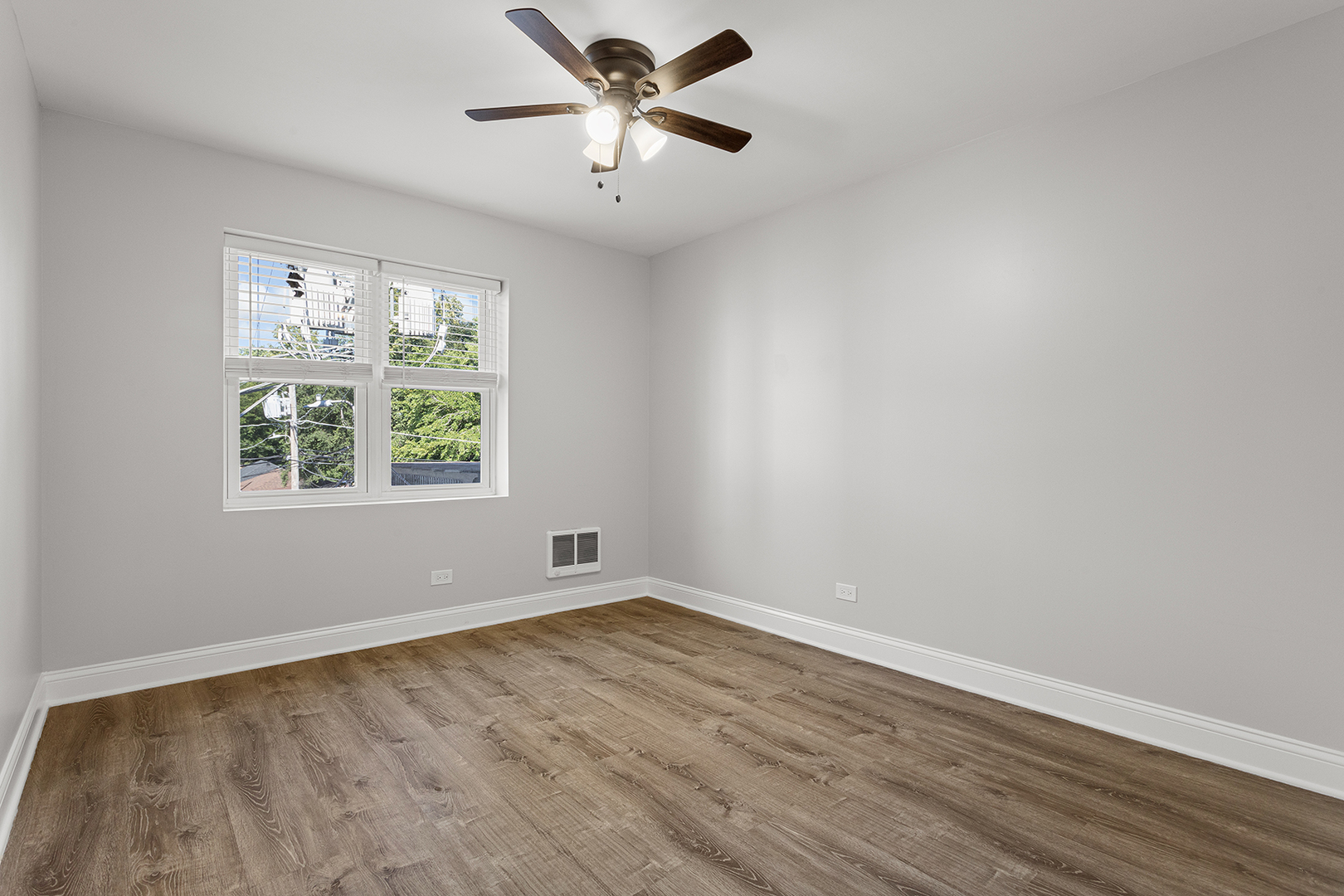 7710 North Sheridan Road, Unit 304 Chicago, IL 60626 - Photo 7 of 13 an empty room with wooden floor and windows