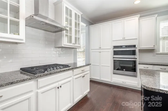 a kitchen with granite countertop a stove and a sink