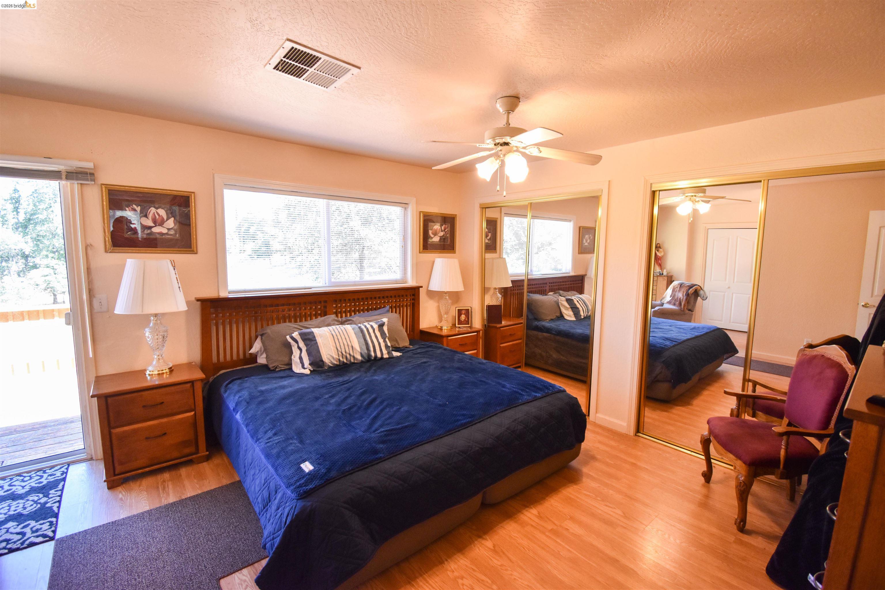 13904 Tuolumne Road Sonora, CA 95370 - Photo 25 of 44 Bedroom featuring wood-finish flooring, a ceiling fan, and sliding mirror closet doors