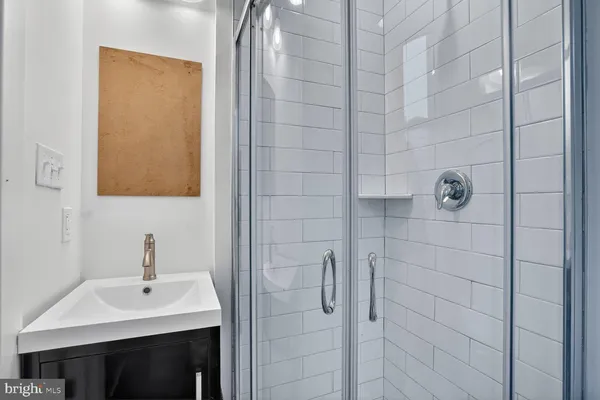 a bathroom with a sink shower and a mirror