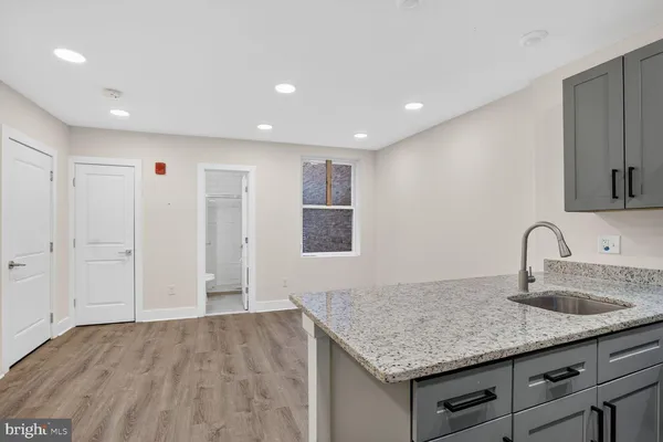 a kitchen with sink and mirror