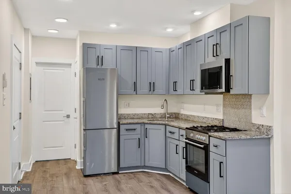 a kitchen with stainless steel appliances granite countertop a refrigerator and a stove top oven
