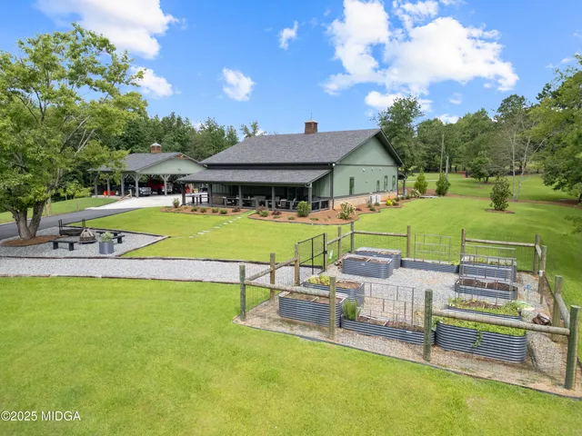 a view of a house with a big yard and large trees