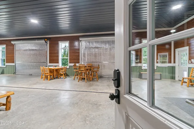 an aerial view of residential house with outdoor space and trees all around
