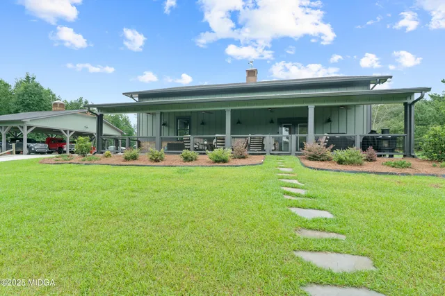 a room with stainless steel appliances kitchen island granite countertop lots of counter space and a sink