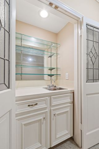 a kitchen with white cabinets and sink
