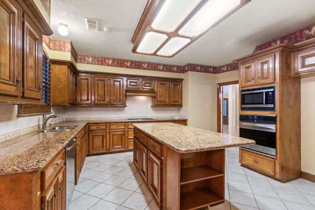 a kitchen with stainless steel appliances granite countertop a sink and cabinets