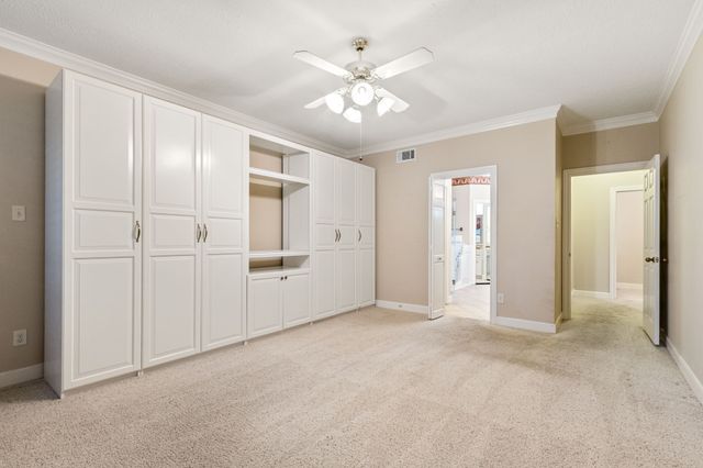 an empty room with closet and a ceiling fan