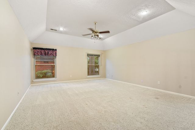 an empty room with windows and cabinet