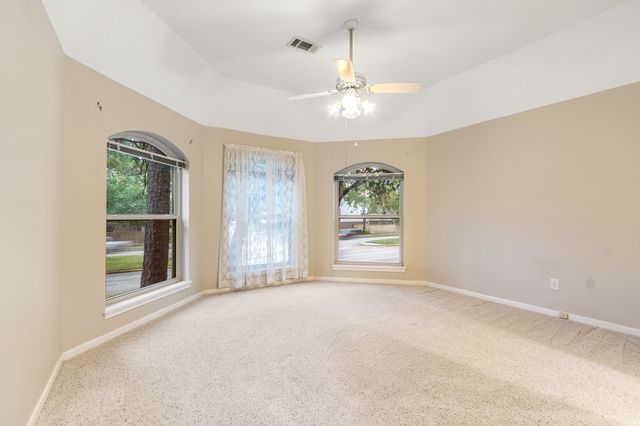 an empty room with windows and chandelier