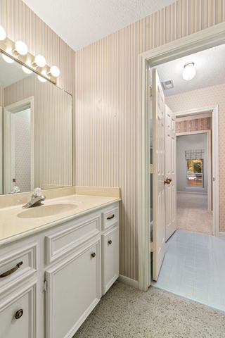 a spacious bathroom with a granite countertop sink and a mirror
