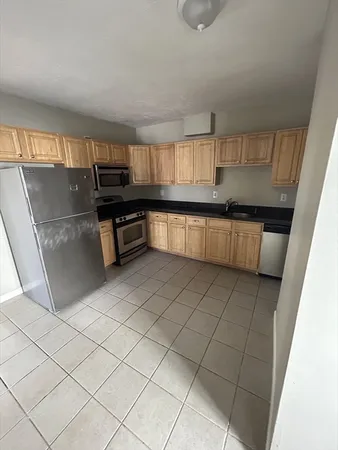 a kitchen with kitchen island granite countertop a sink cabinets and stainless steel appliances