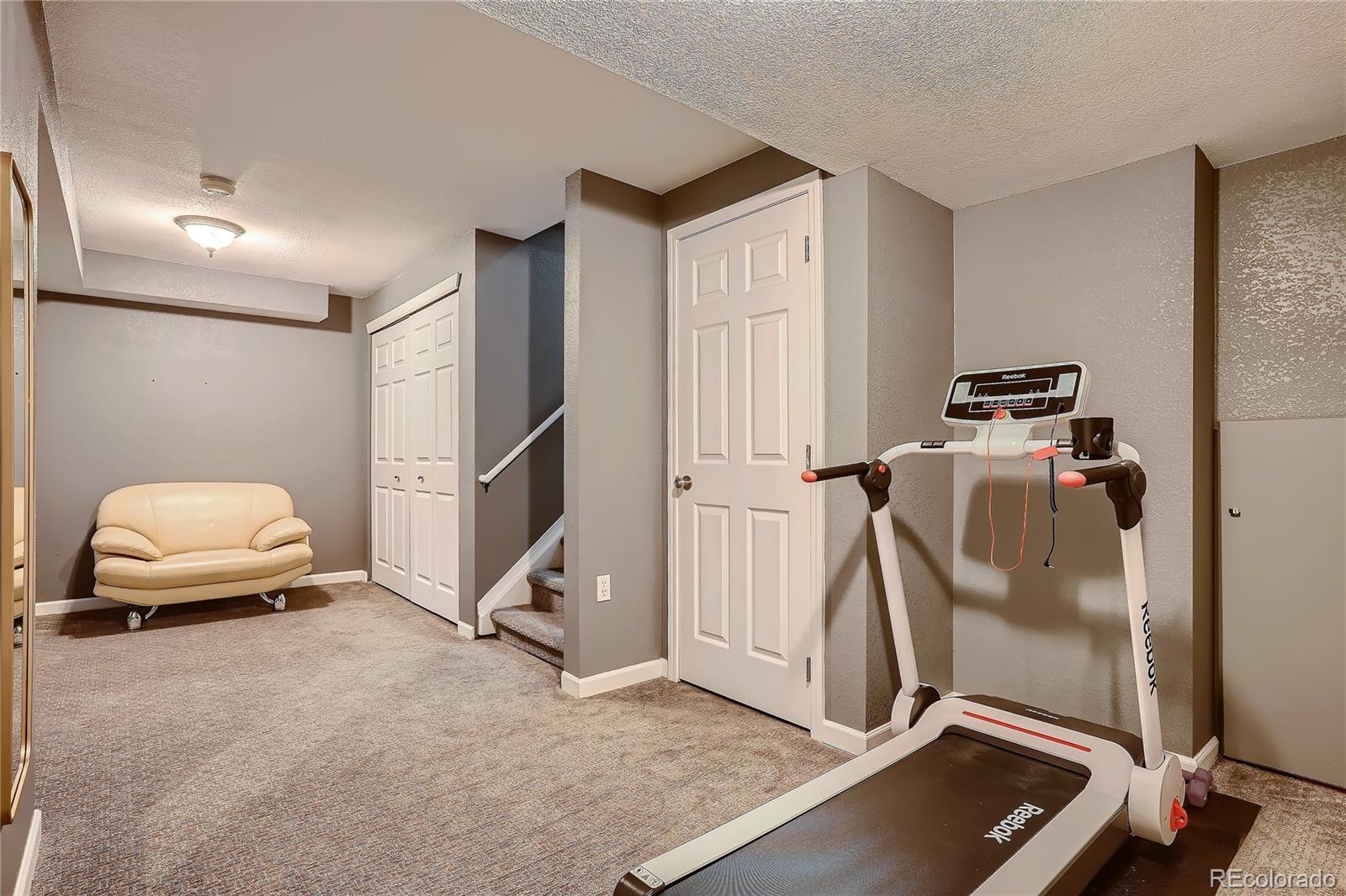 8994 Bermuda Run Circle Highlands Ranch, CO 80130 - Photo 25 of 30 a room with gym equipment and a view of living room